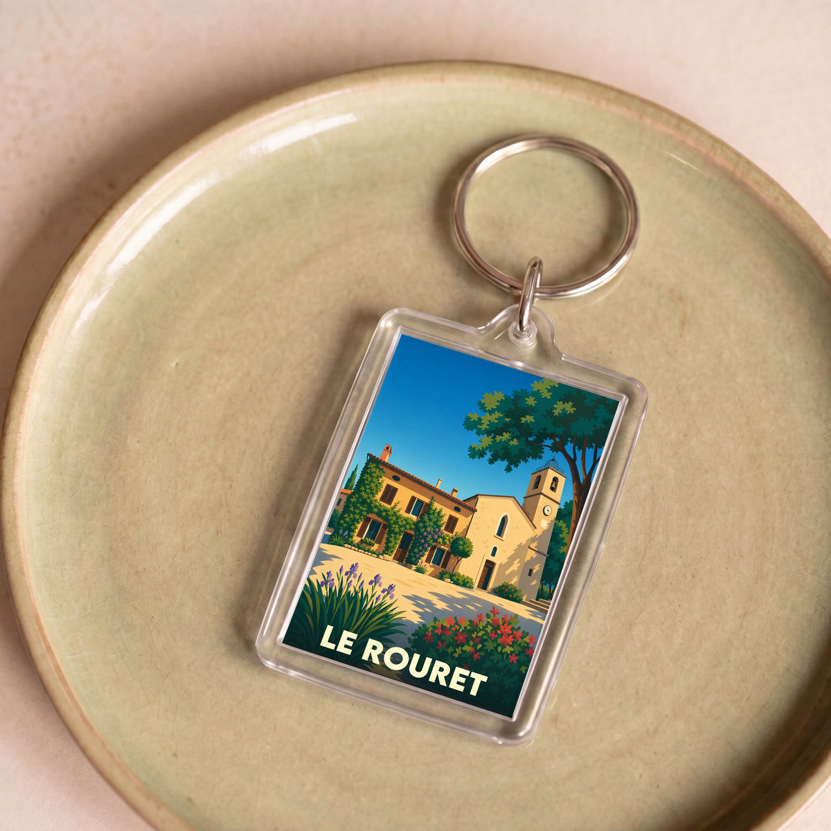Porte-clés souvenir de la ville de Le Rouret avec une illustration stylisée.