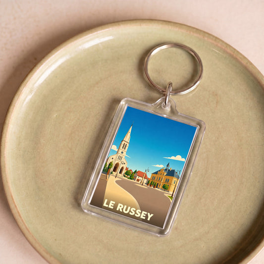 Porte-clés souvenir de la ville de Le Russey avec une illustration stylisée.