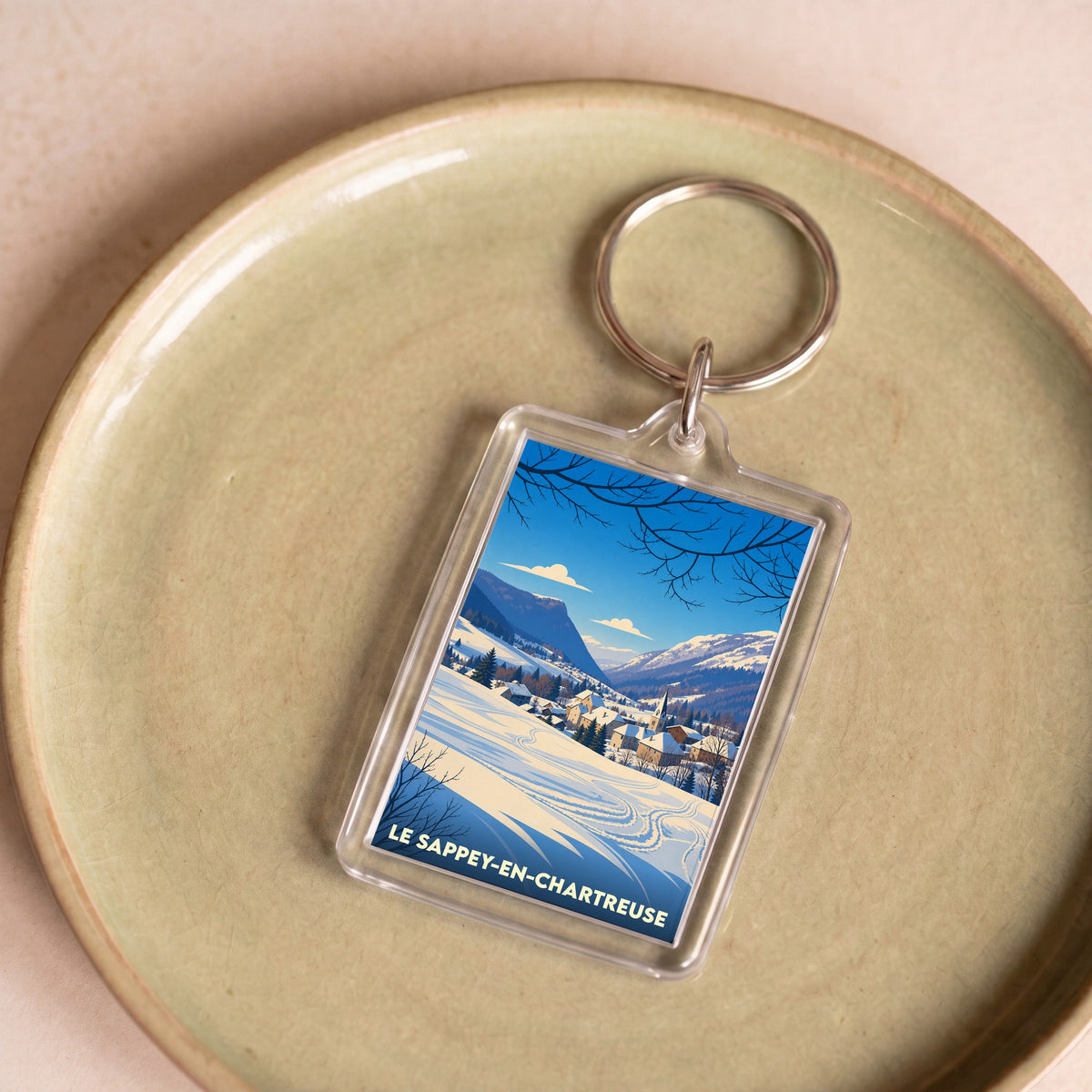 Porte-clés souvenir de la commune de Le Sappey-en-Chartreuse avec une illustration hivernale stylisée.