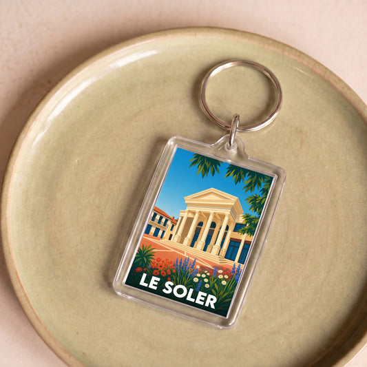Porte-clés souvenir de la ville de Le Soler avec une illustration stylisée.