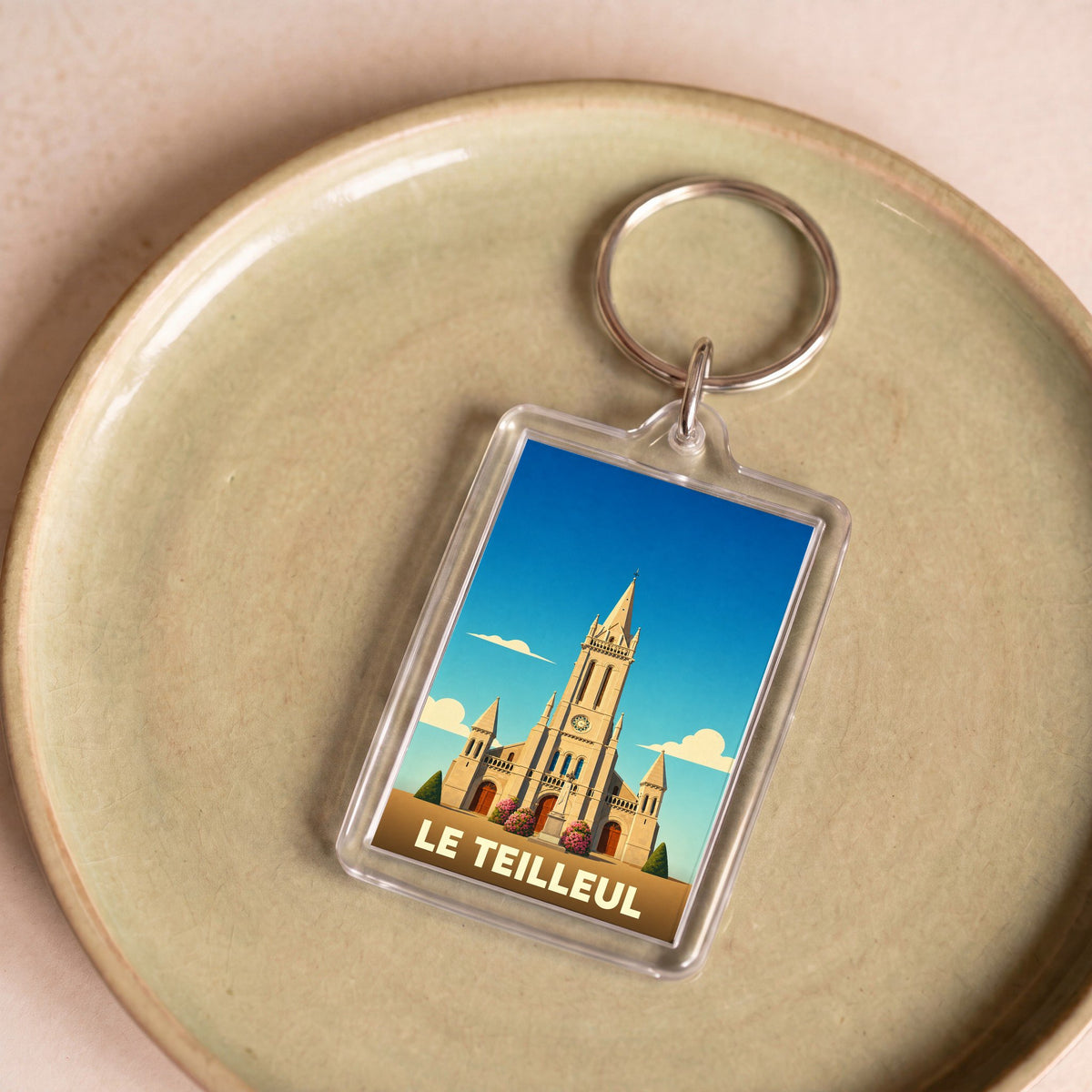 Porte-clés souvenir de la ville de Le Teilleul avec une illustration stylisée de son église.