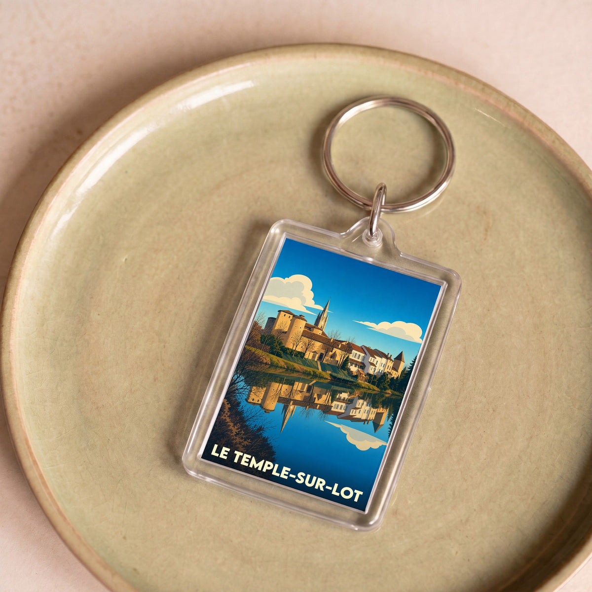 Porte-clés souvenir de la ville du Temple-sur-Lot avec une illustration stylisée.