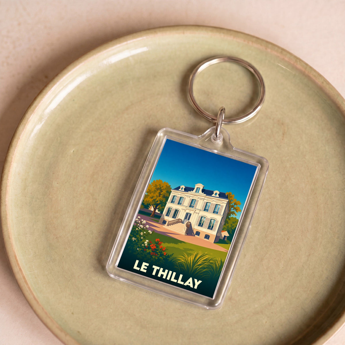 Porte-clés souvenir de la ville de Le Thillay avec une illustration stylisée.