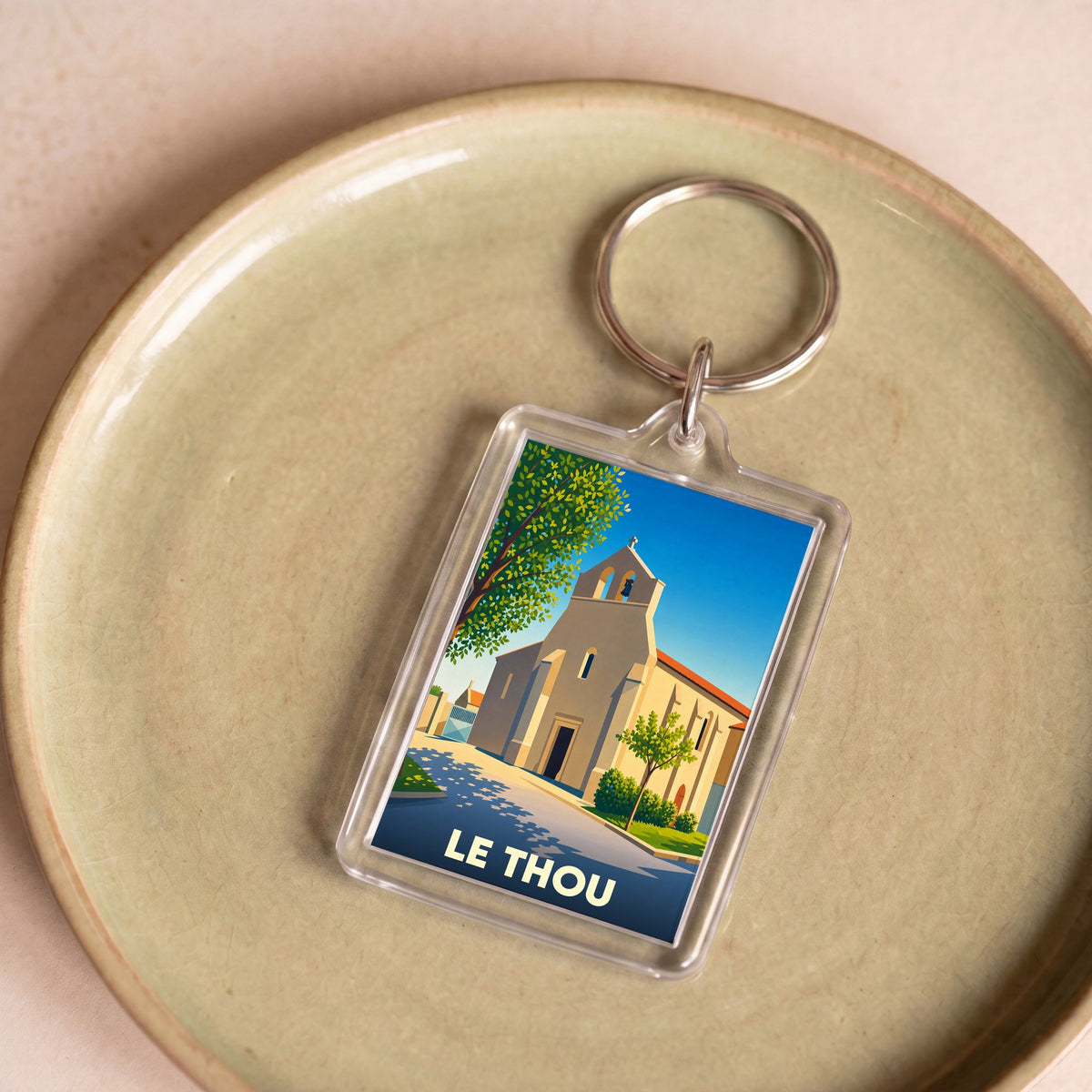 Porte-clés souvenir de la ville de Le Thou avec une illustration stylisée de son église.