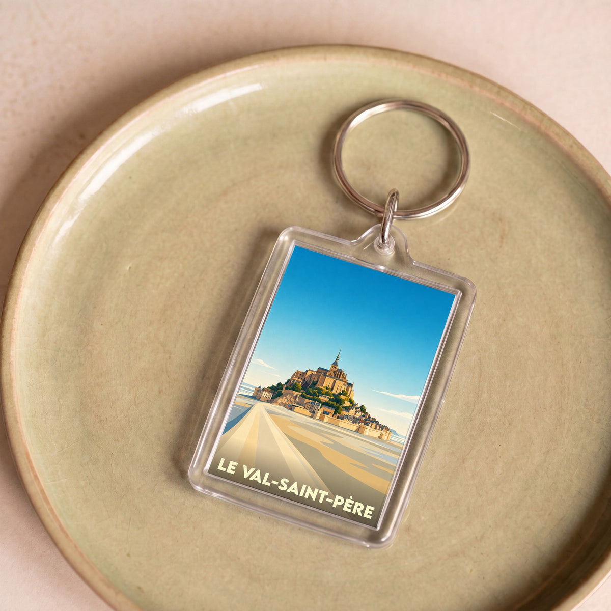 Porte-clés souvenir de la ville de Le Val-Saint-Père avec une illustration stylisée du Mont-Saint-Michel.