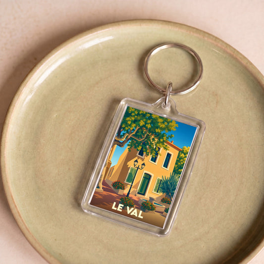 Porte-clés souvenir de la ville de Le Val avec une illustration stylisée d'une maison provençale.