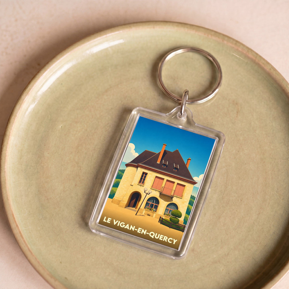 Porte-clés souvenir de la ville de Le Vigan-en-Quercy avec une illustration stylisée.