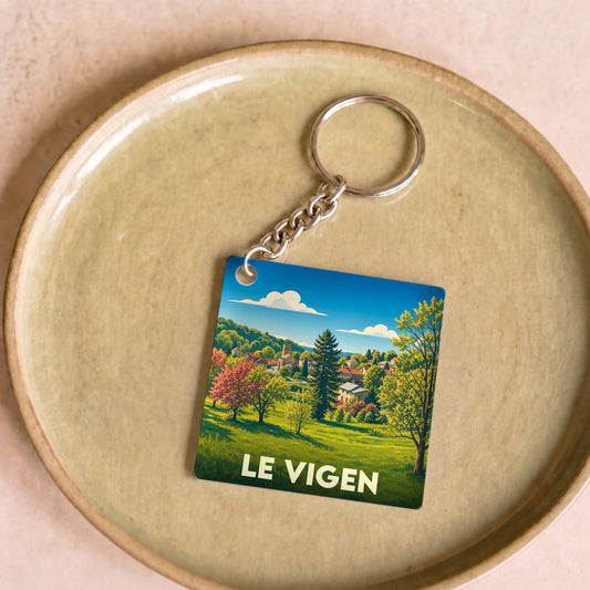 Porte-clés souvenir de la ville de Le Vigen avec une illustration paysagère stylisée.