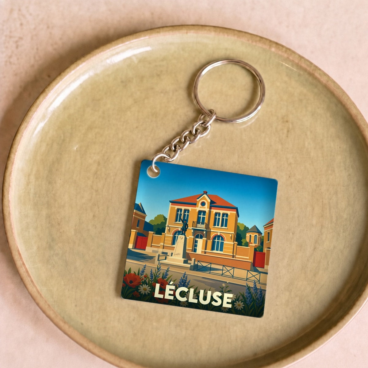 Porte-clés souvenir de la ville de Lécluse avec une illustration stylisée.