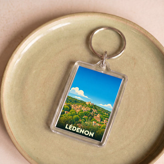 Porte-clés souvenir de la ville de Lédenon avec une illustration stylisée.