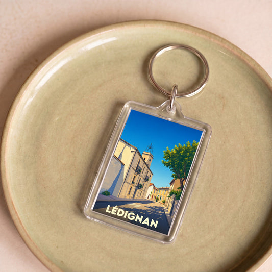 Porte-clés souvenir de la ville de Lédignan avec une illustration stylisée.