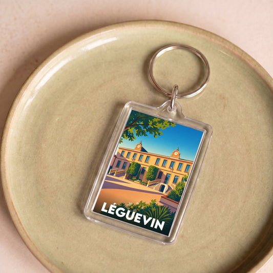 Porte-clés souvenir de la ville de Léguevin avec une illustration stylisée.