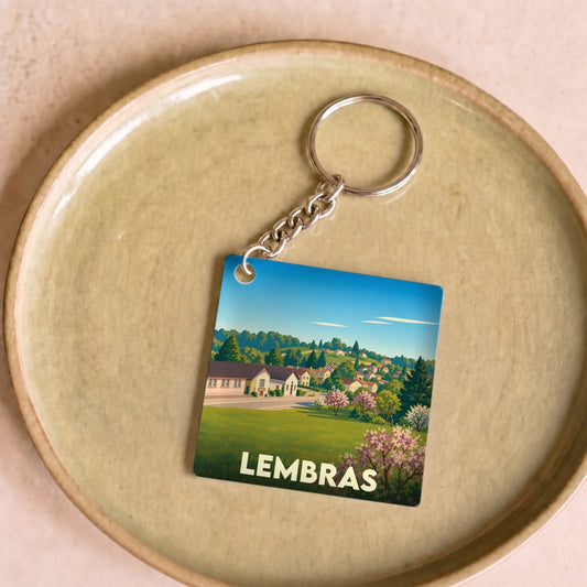Porte-clés souvenir de la ville de Lembras avec une illustration champêtre stylisée.