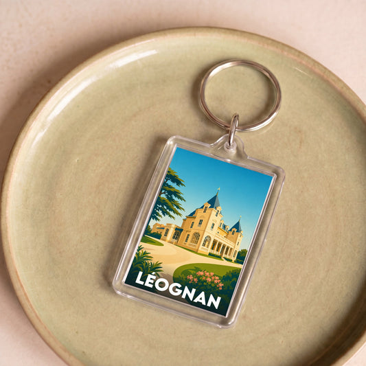 Porte-clés souvenir de la ville de Léognan avec une illustration stylisée.