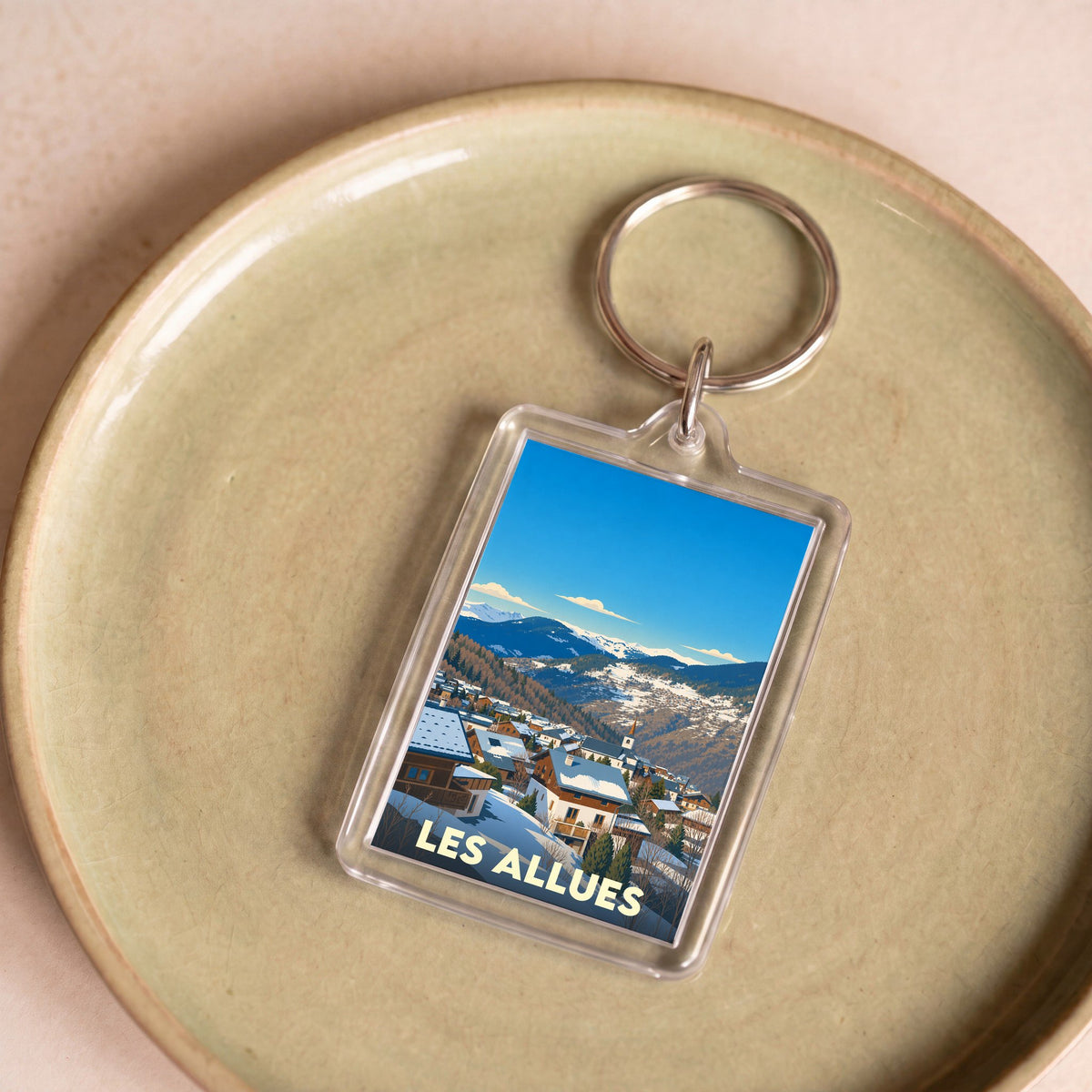 Porte-clés souvenir de la ville de Les Allues avec une illustration stylisée.