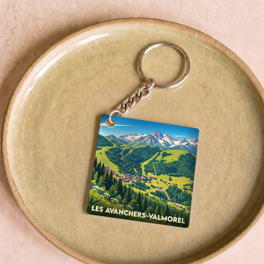 Porte-clés souvenir de la ville de Les Avanchers-Valmorel avec une illustration de paysages de montagne.