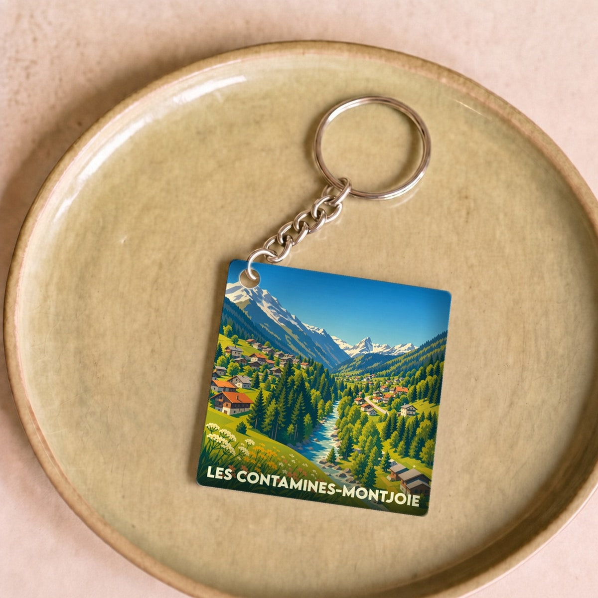 Porte-clés souvenir de la ville de Les Contamines-Montjoie avec une illustration stylisée de montagne.