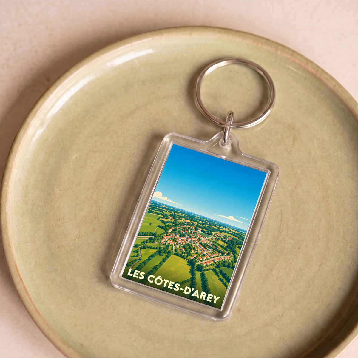 Porte-clés souvenir de la ville de Les Côtes-d'Arey avec une vue aérienne illustrée.