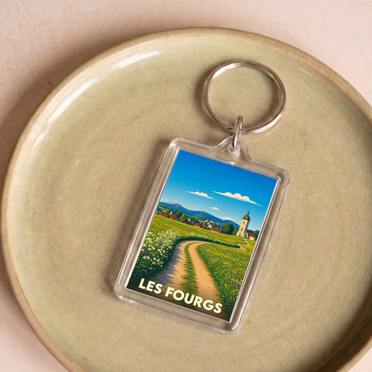 Porte-clés souvenir de la ville de Les Fourgs avec une illustration stylisée d'un paysage de campagne.