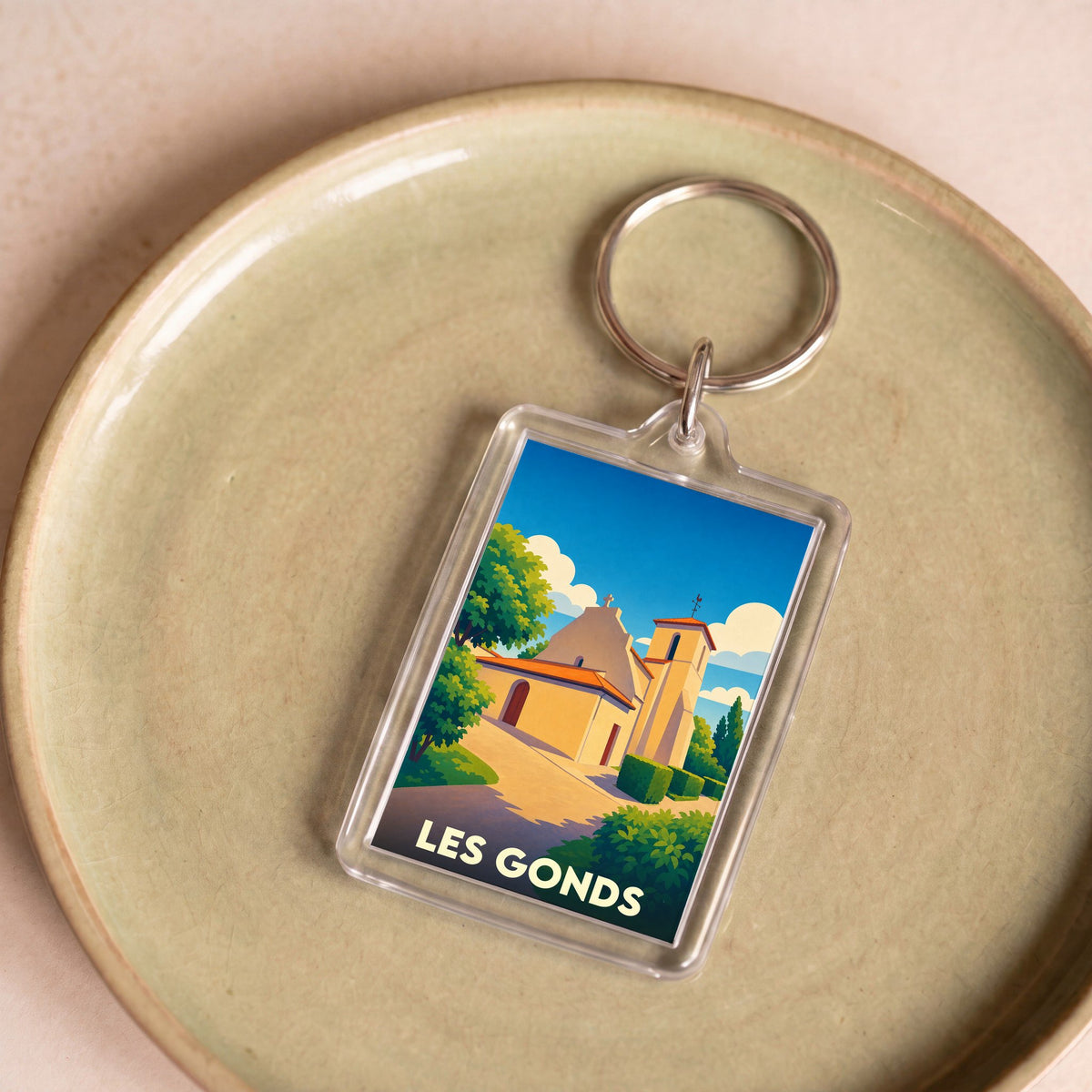 Porte-clés souvenir de la ville de Les Gonds avec une illustration stylisée de son église.