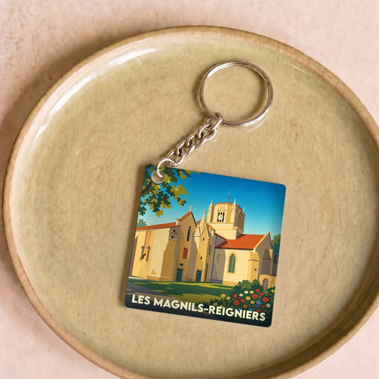 Porte-clés souvenir de la ville de Les Magnils-Reigniers avec une illustration stylisée de son église.