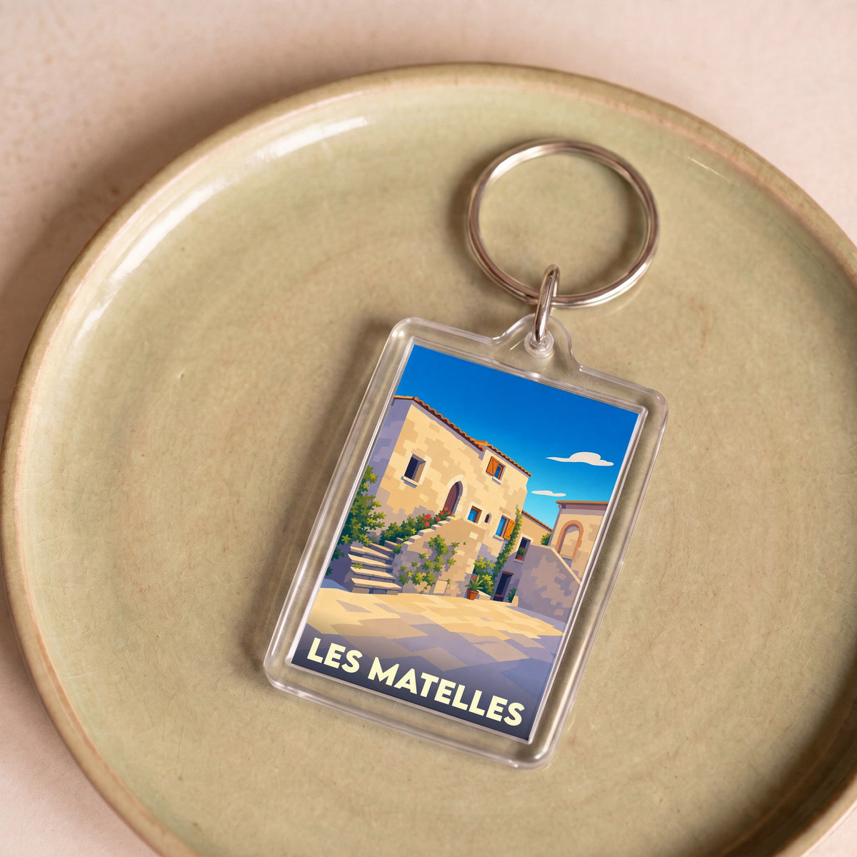 Porte-clés souvenir de la ville de Les Matelles avec une illustration stylisée.