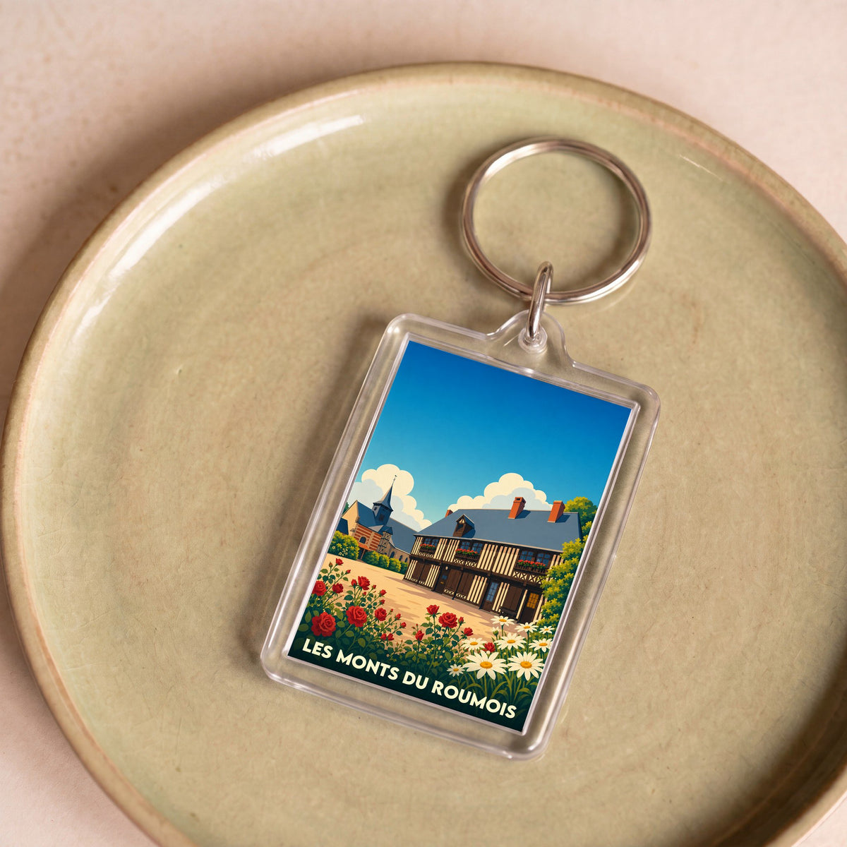 Porte-clés souvenir de la ville de Les Monts du Roumois avec une illustration stylisée.