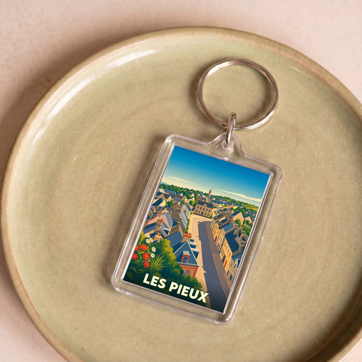 Porte-clés souvenir de la ville de Les Pieux avec une illustration stylisée.