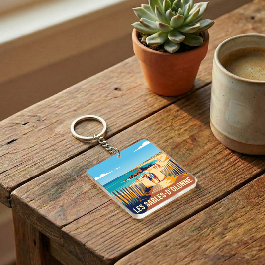 Porte-clés souvenir de la ville de Les Sables-d'Olonne avec une illustration de plage stylisée.
