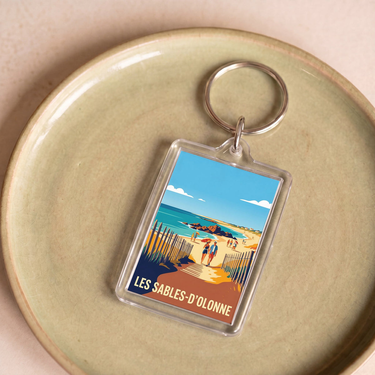Porte-clés souvenir de la ville de Les Sables-d'Olonne avec une illustration de plage stylisée.