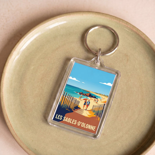 Porte-clés souvenir de la ville de Les Sables-d'Olonne avec une illustration de plage stylisée.