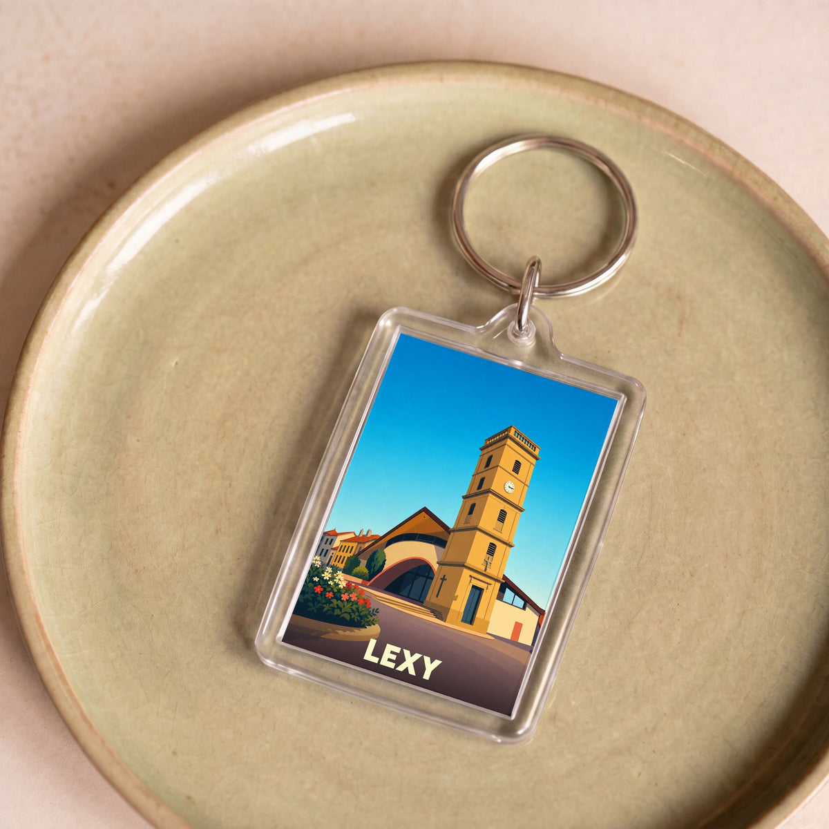 Porte-clés souvenir de la ville de Lexy avec une illustration stylisée de son église.