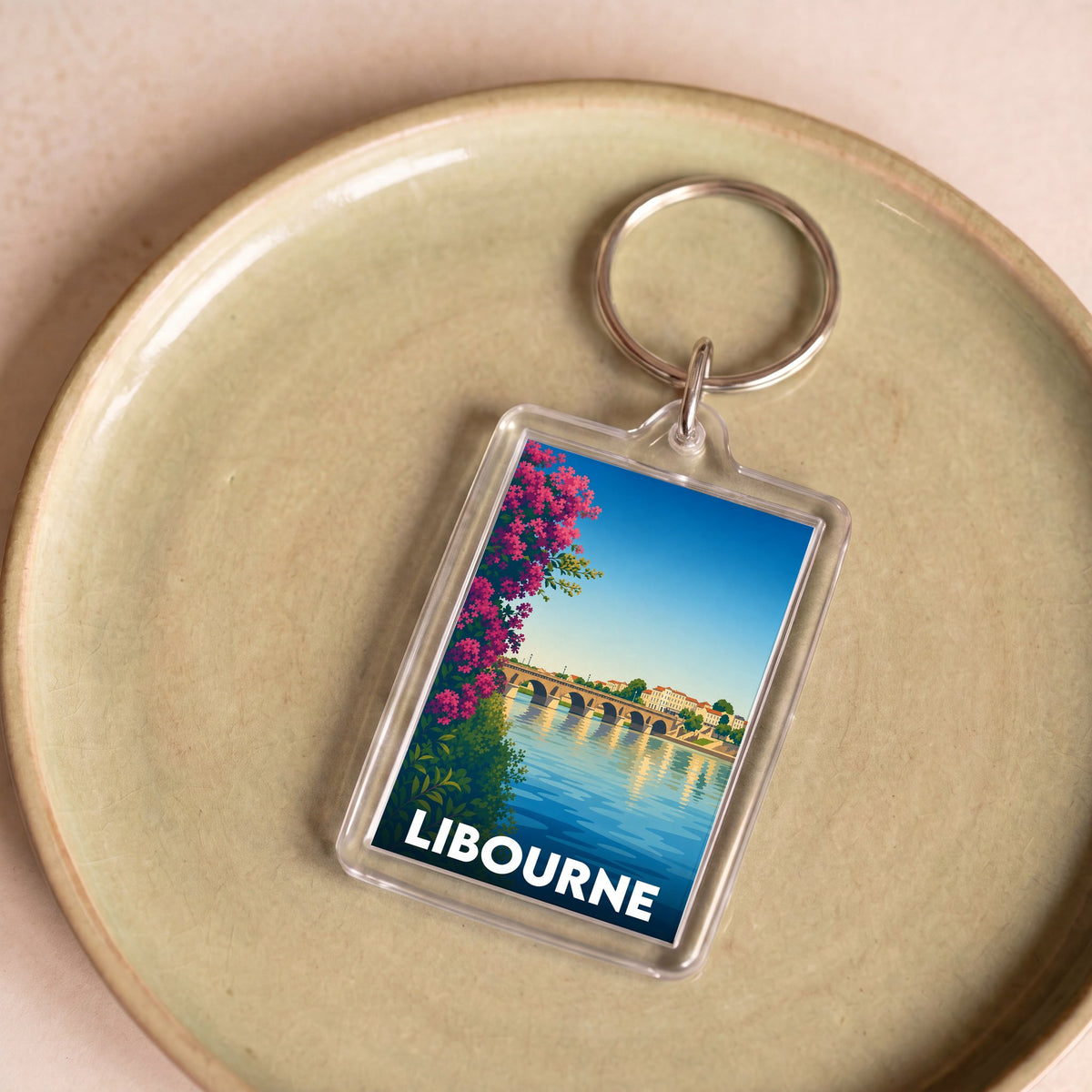 Porte-clés souvenir de la ville de Libourne avec une illustration stylisée d'un pont historique.