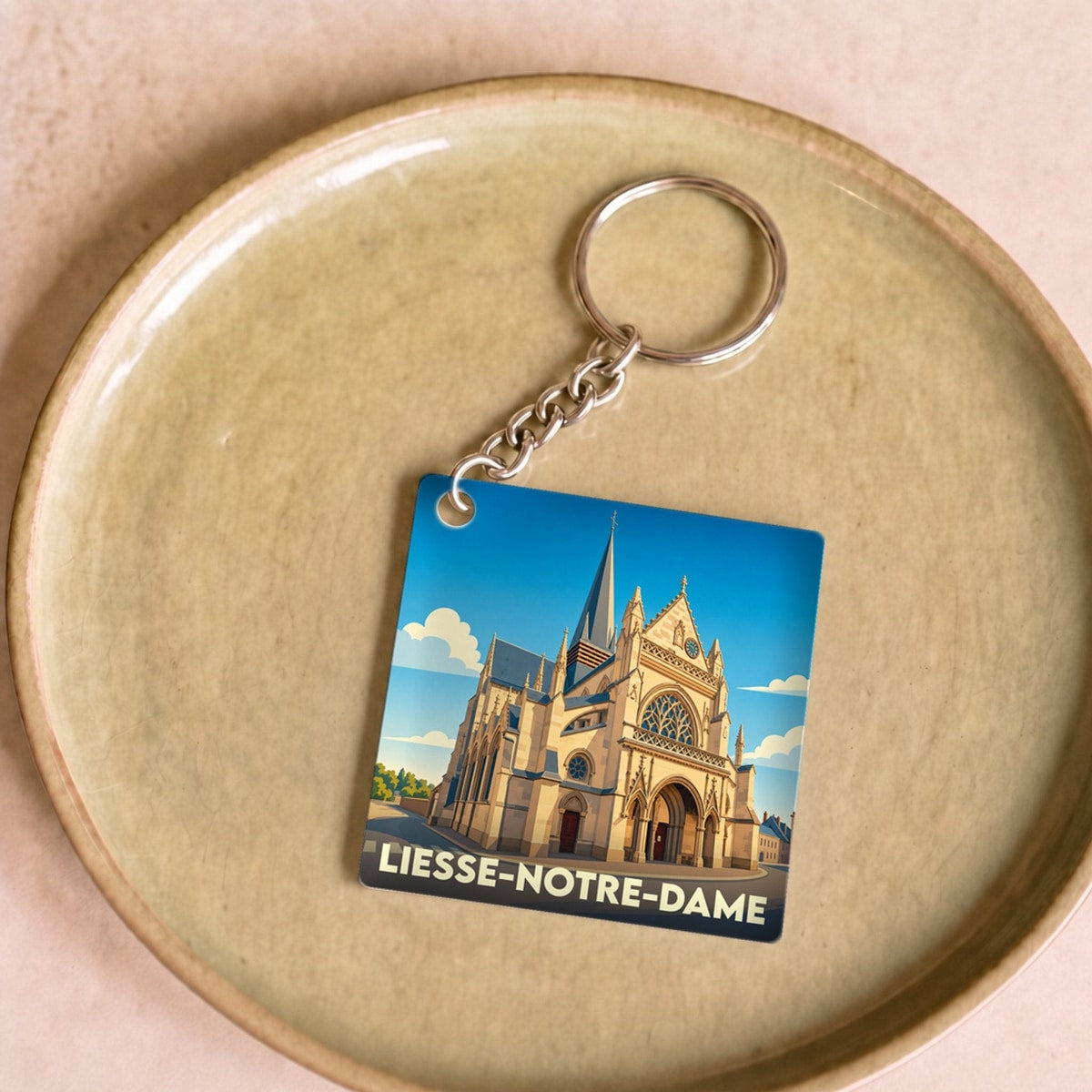 Porte-clés souvenir de la ville de Liesse-Notre-Dame avec une illustration stylisée de sa basilique.