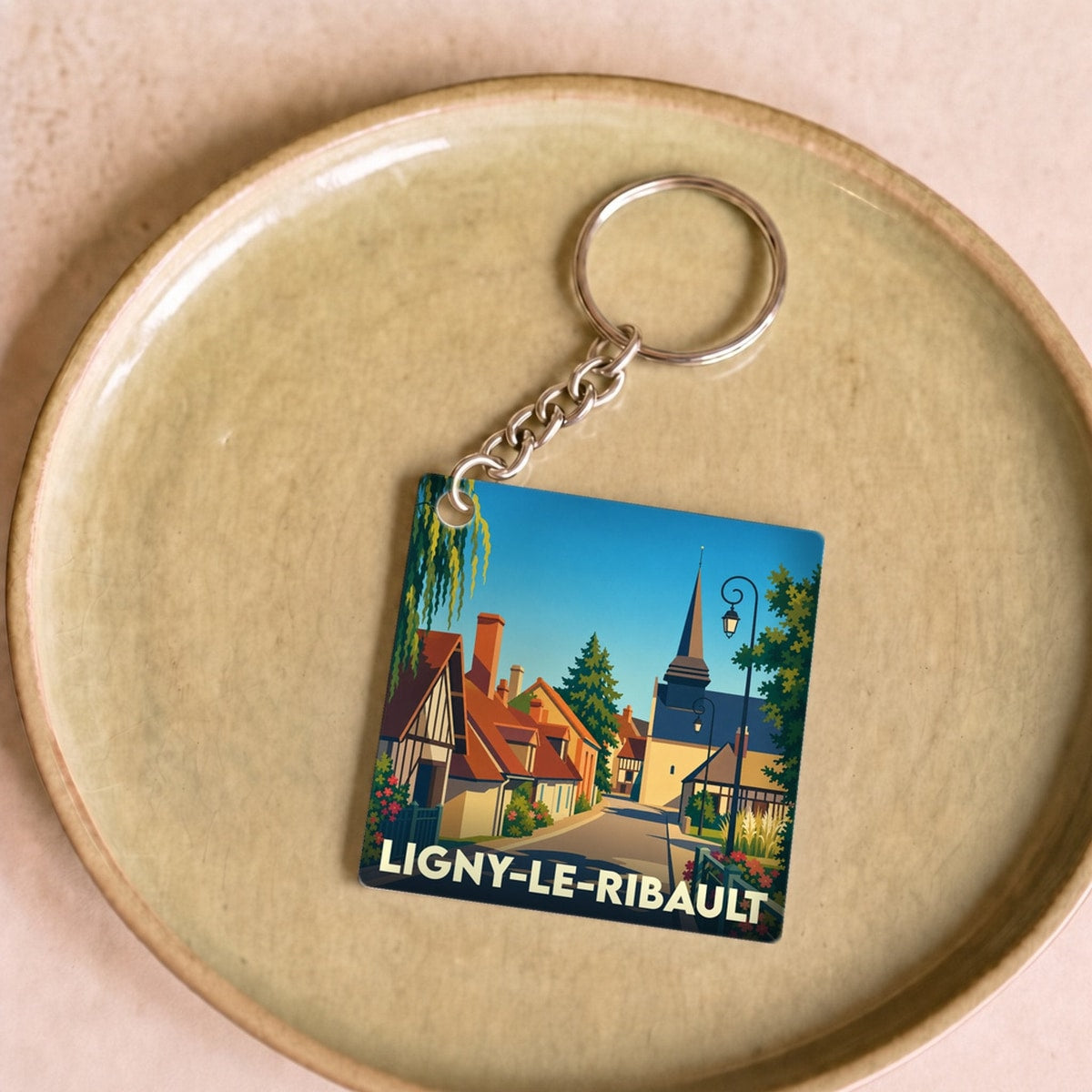 Porte-clés souvenir de la ville de Ligny-le-Ribault avec une illustration stylisée.