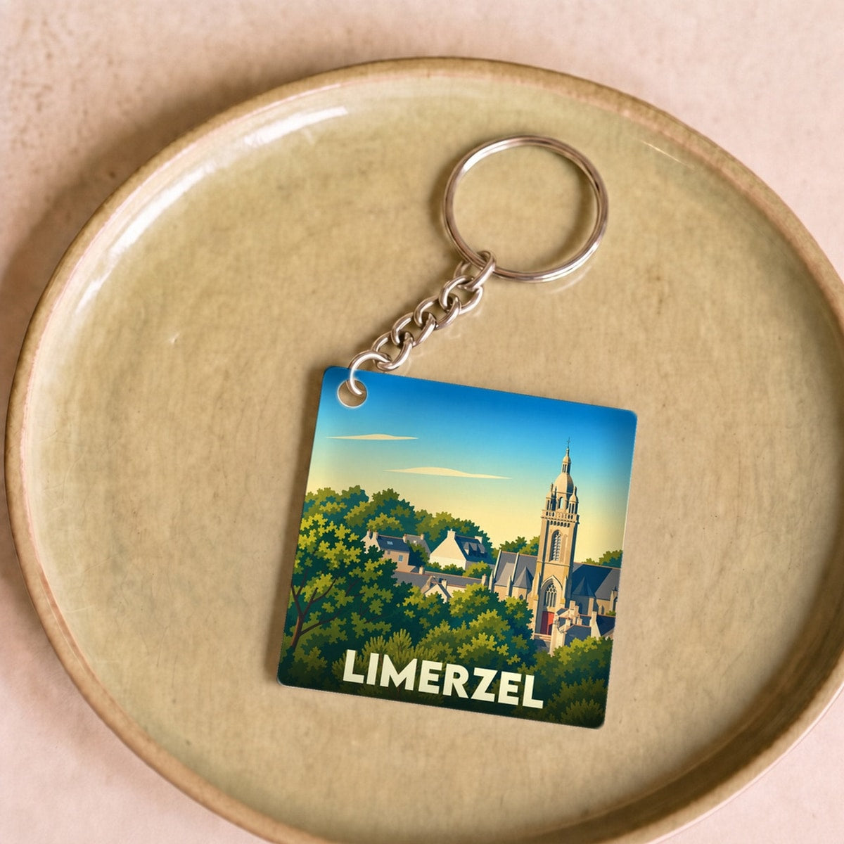 Porte-clés souvenir de la ville de Limerzel avec une illustration stylisée d'une église entourée de verdure.