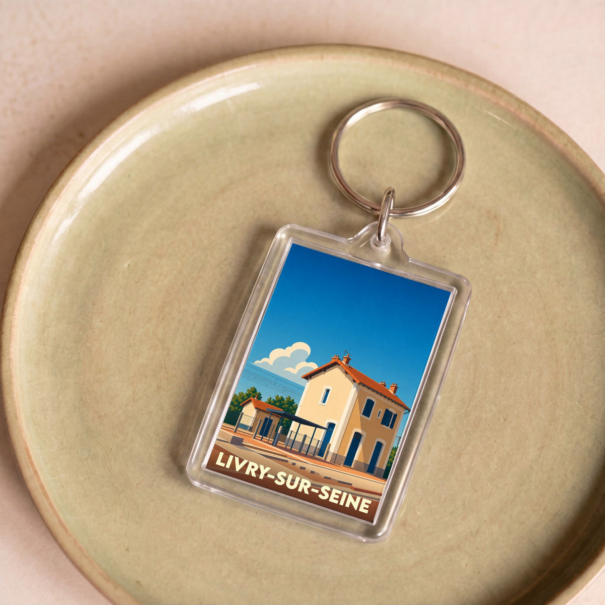 Porte-clés souvenir de la ville de Livry-sur-Seine avec une illustration stylisée de sa gare.