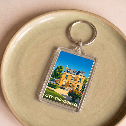 Porte-clés souvenir de la ville de Lizy-sur-Ourcq avec une illustration stylisée d'une demeure bourgeoise.