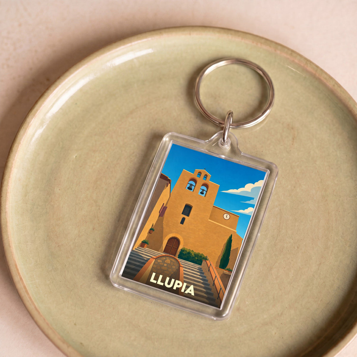 Porte-clés souvenir de la ville de Llupia avec une illustration stylisée de son église.