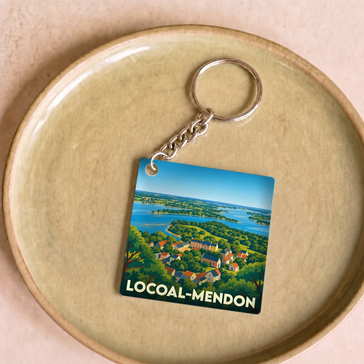 Porte-clés souvenir de la ville de Locoal-Mendon avec une illustration stylisée d'un paysage côtier.