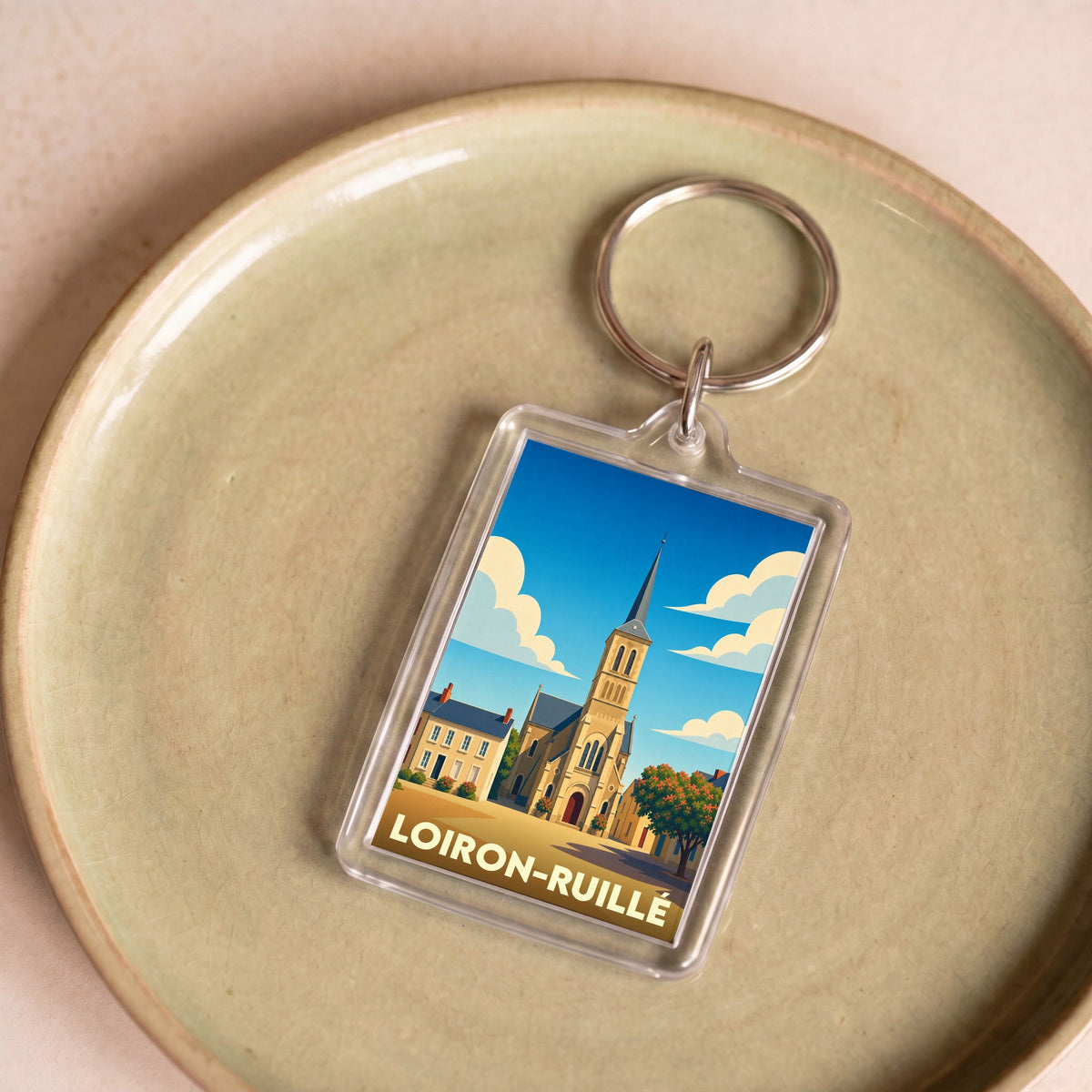 Porte-clés souvenir de la ville de Loiron-Ruillé avec une illustration stylisée de son église.