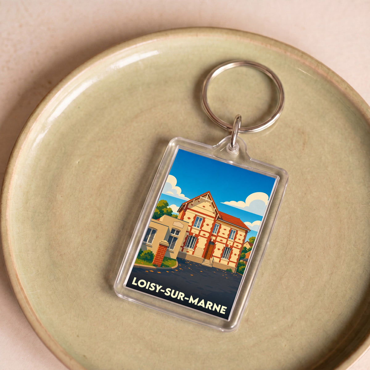 Porte-clés souvenir de la ville de Loisy-sur-Marne avec une illustration stylisée d'une maison traditionnelle.