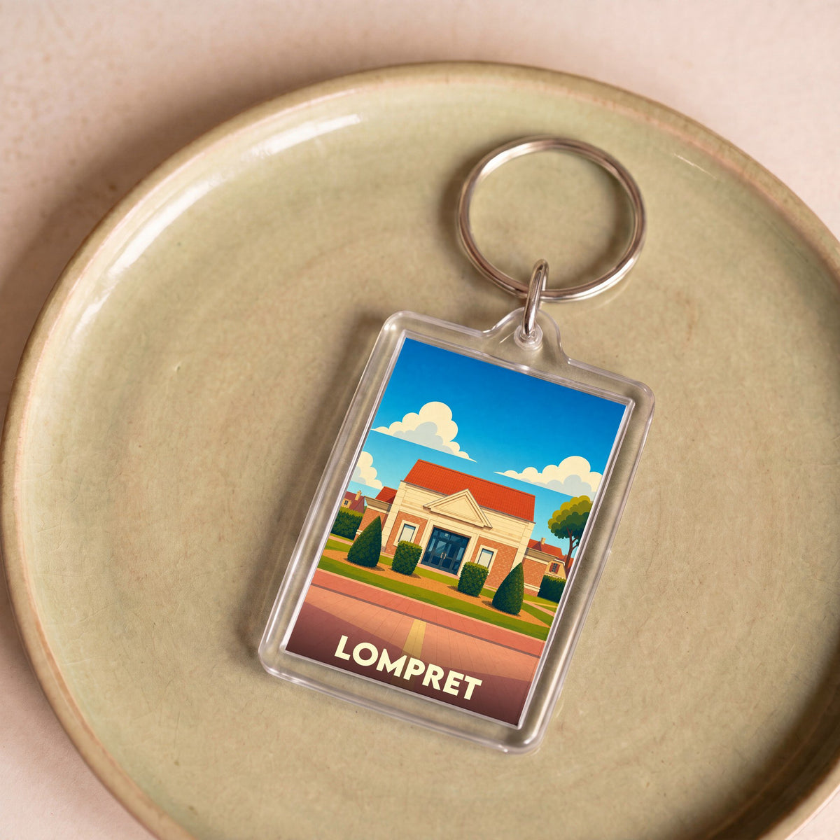 Porte-clés souvenir de la ville de Lompret avec une illustration stylisée.
