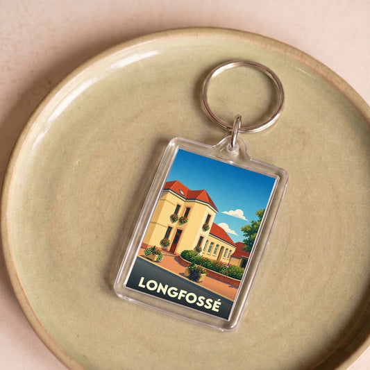 Porte-clés souvenir de la ville de Longfossé avec une illustration stylisée d'un bâtiment fleuri.