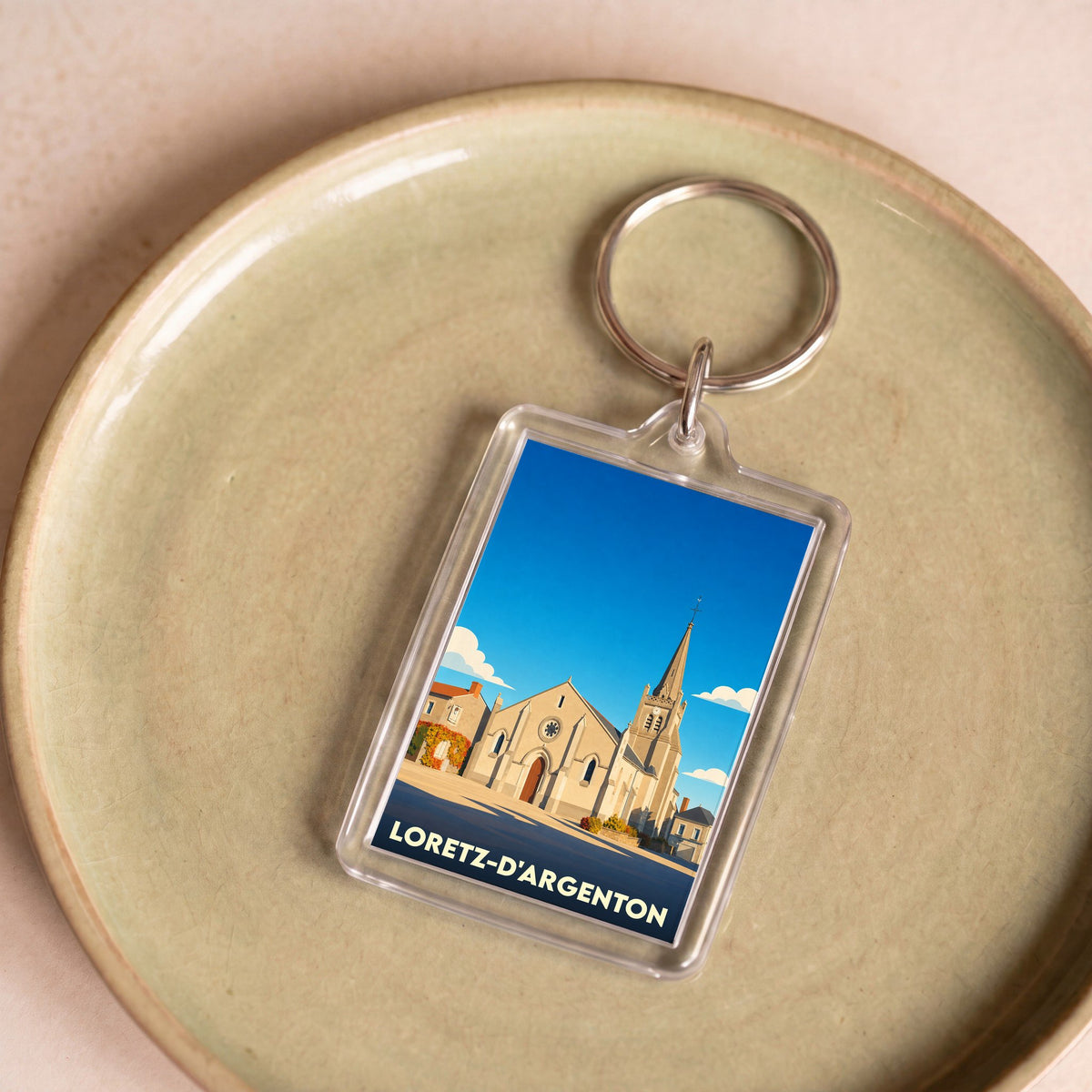 Porte-clés souvenir de la commune de Loretz-d'Argenton avec une illustration stylisée de son église.