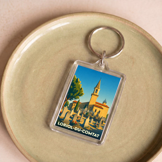 Porte-clés souvenir de la ville de Loriol-du-Comtat avec une illustration stylisée de son église et de son cimetière.