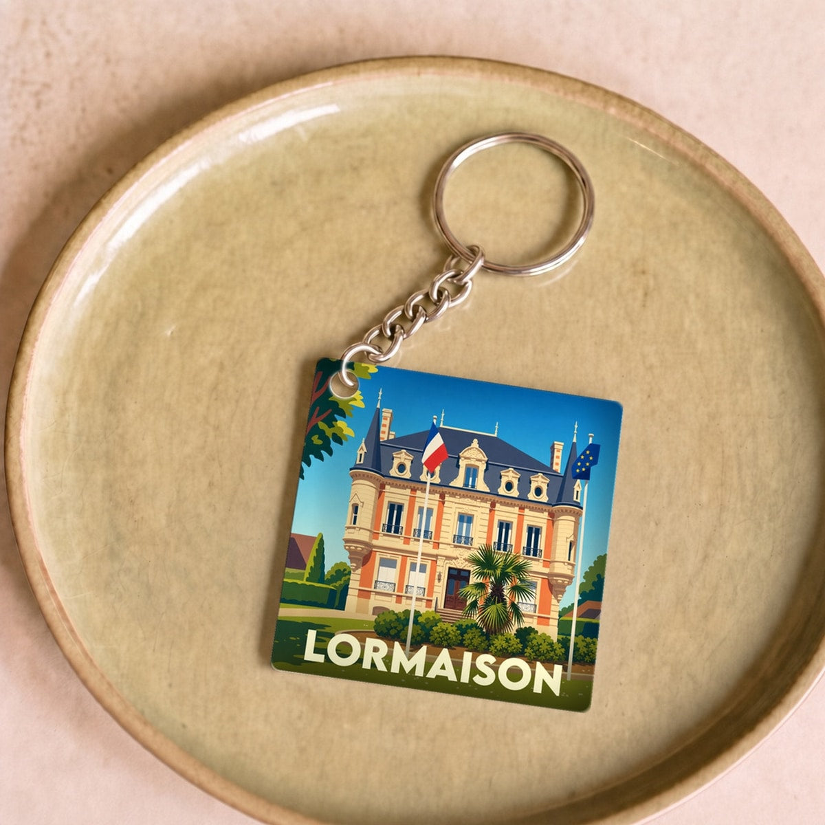 Porte-clés souvenir de la ville de Lormaison avec une illustration stylisée de sa mairie.
