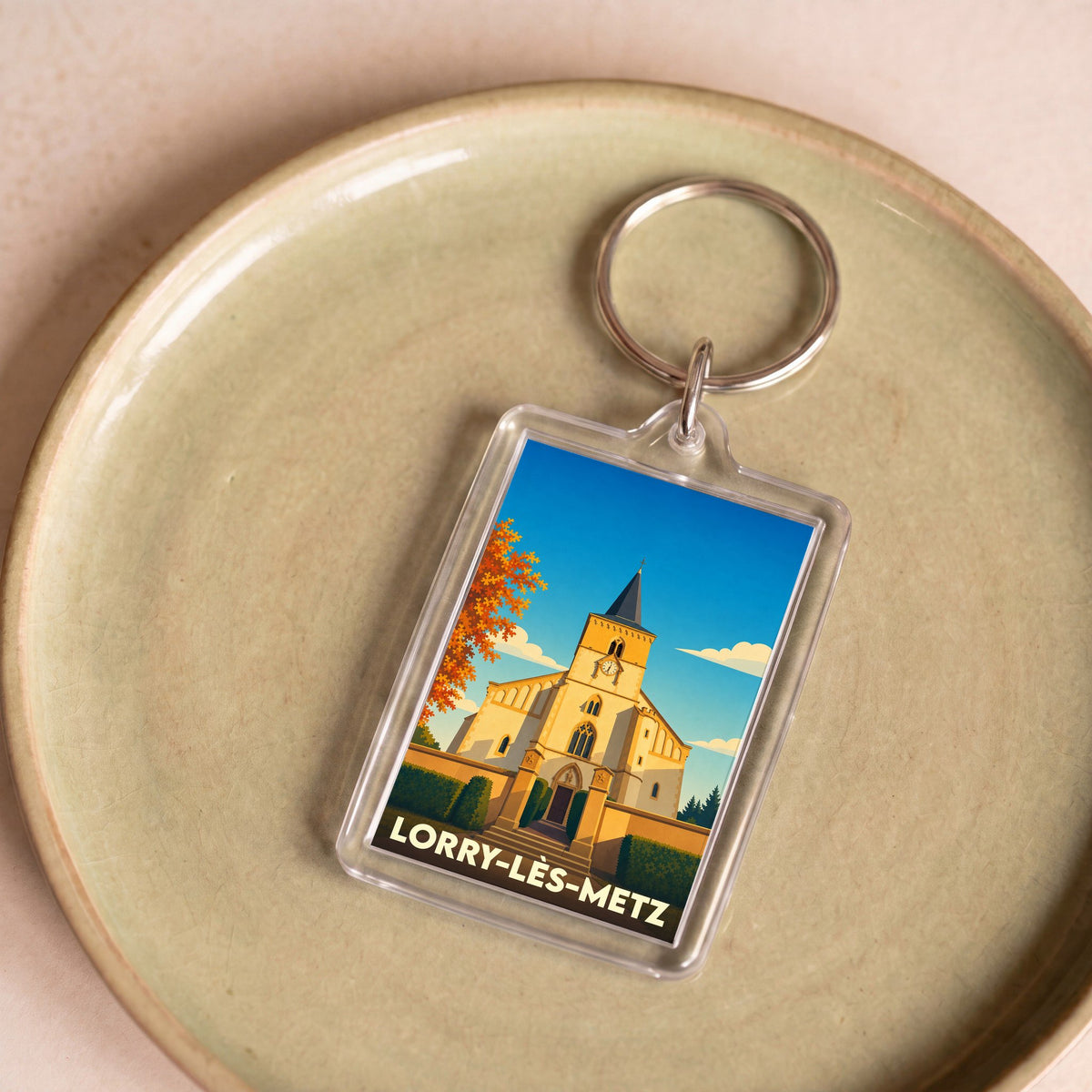Porte-clés souvenir de la ville de Lorry-lès-Metz avec une illustration stylisée de son église.