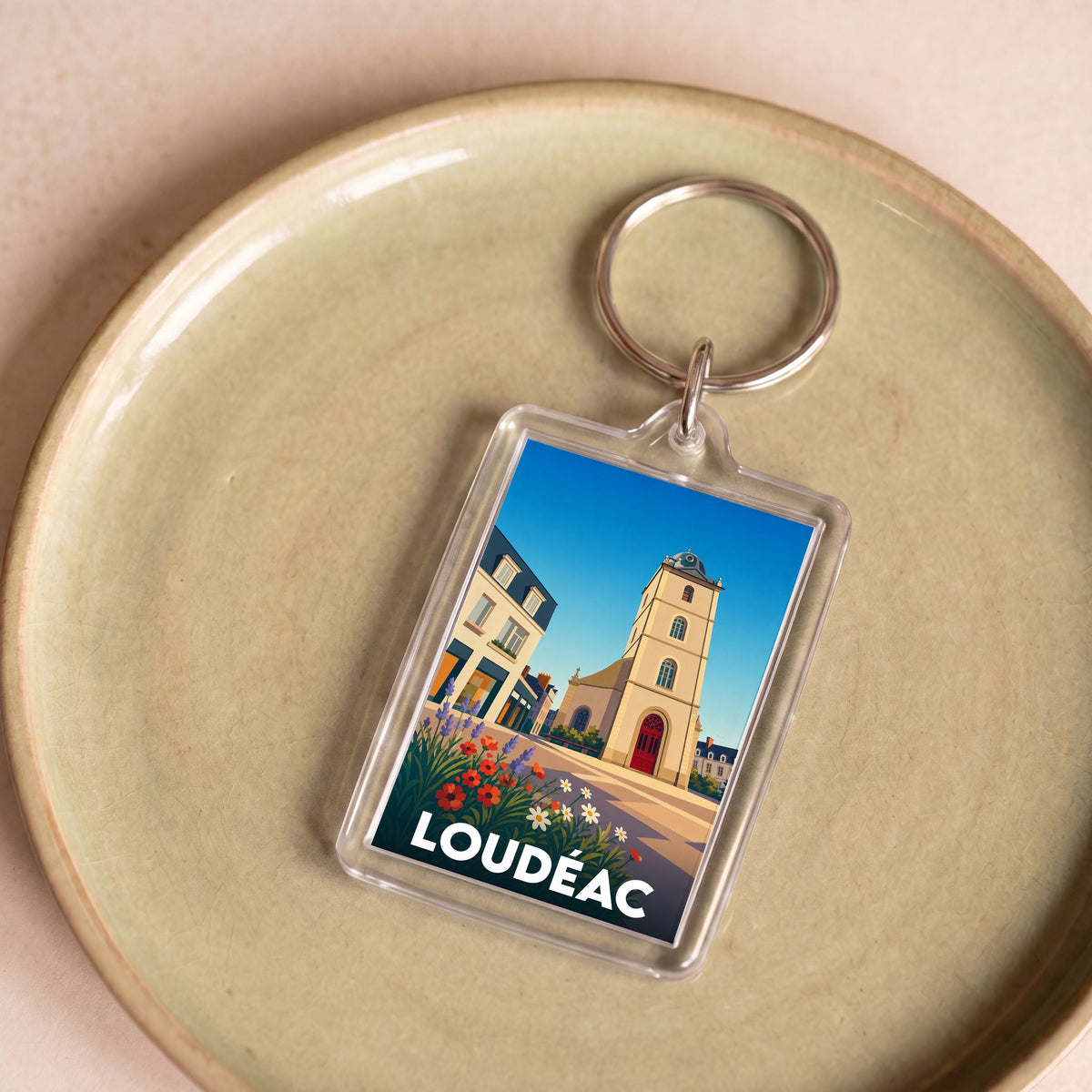 Porte-clés souvenir de la ville de Loudéac avec une illustration stylisée.