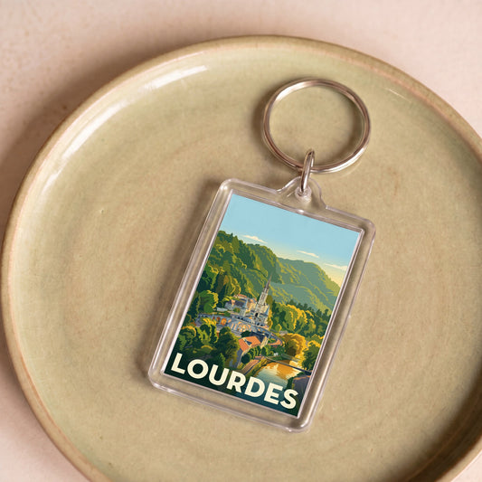 Porte-clés souvenir de la ville de Lourdes avec une illustration stylisée de son sanctuaire.